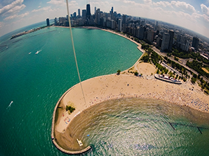 kite flying above north avenue beach in chicago on a late spring day just before summer with views of the chicago skyline and navy pier to the south