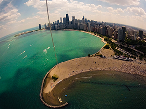kite flying above north avenue beach in chicago on a late spring day just before summer with views of the chicago skyline and navy pier to the south